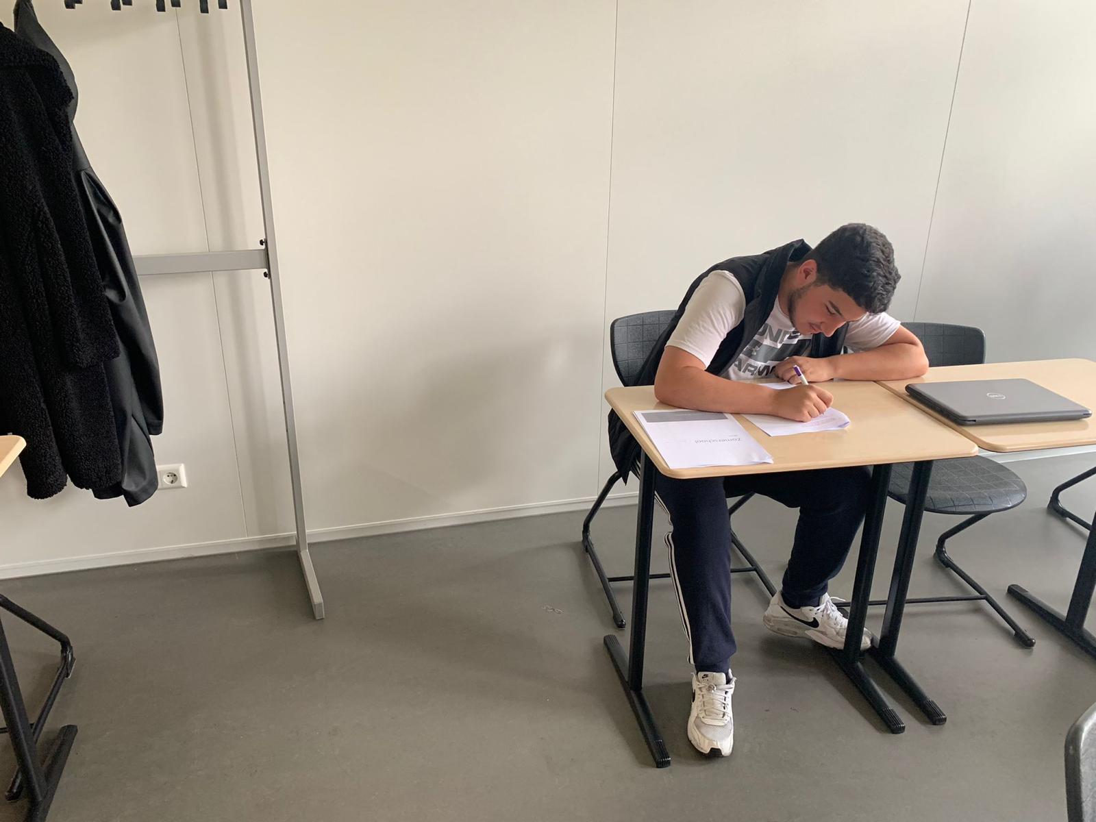 Leerling werkt geconcentreerd met materiaal van de zomerschool