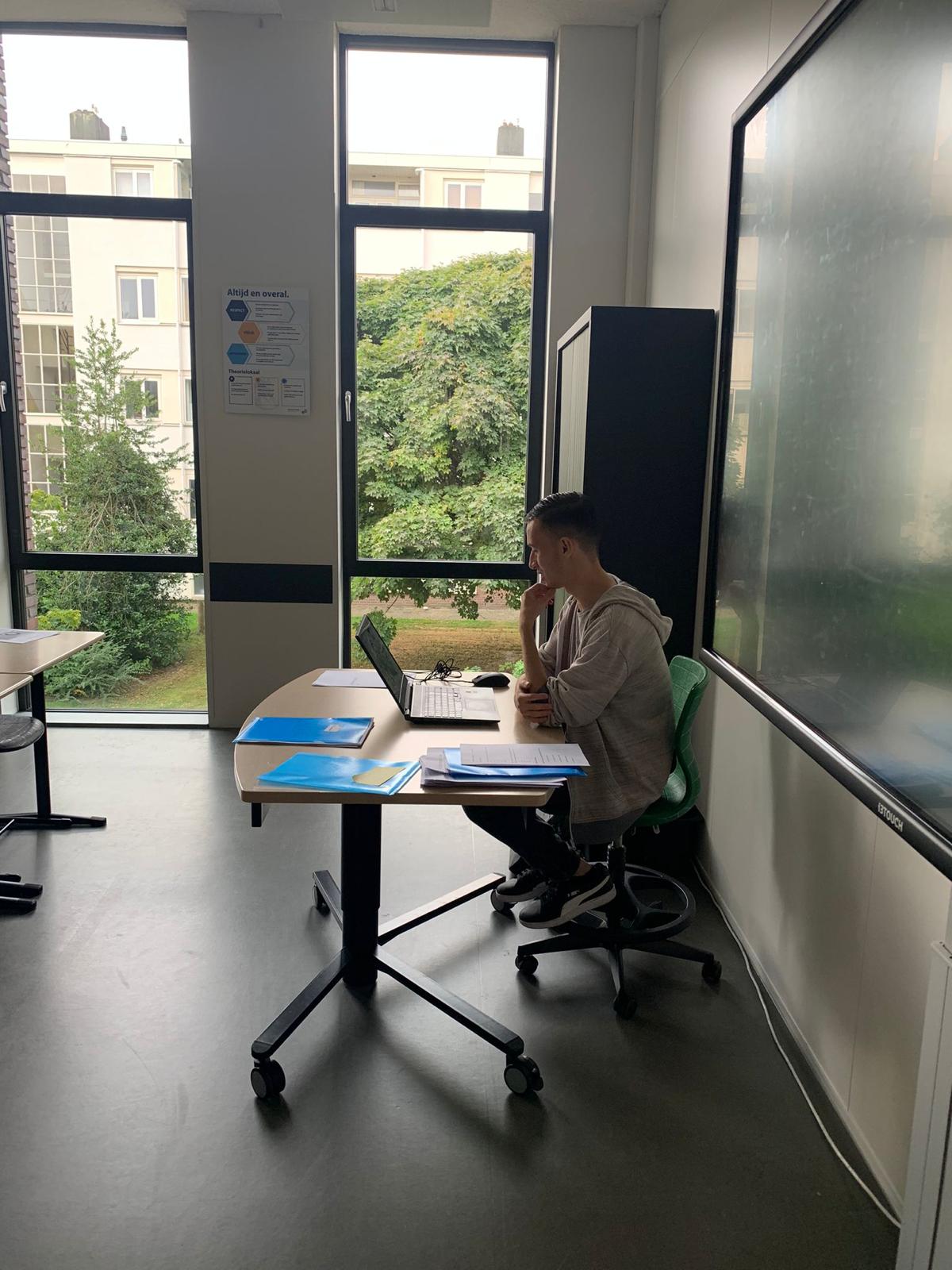 Docent bereidt een les voor aan een bureau met digitaal schoolbord