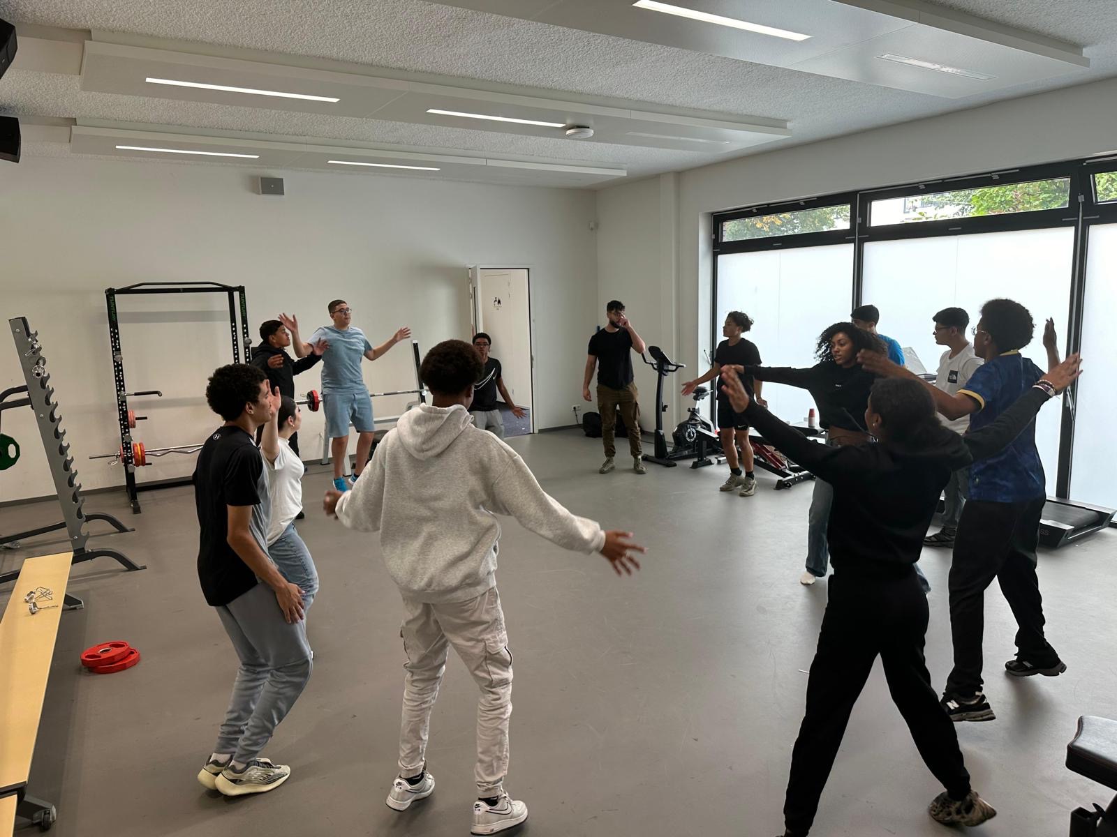 Leerlingen doen samen een actieve warming-up tijdens de vakantieschool