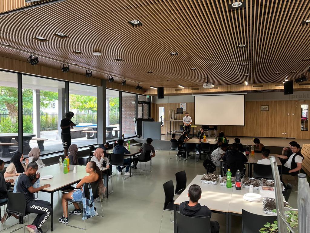 Leerlingen komen samen voor de plenaire start van de vakantieschool