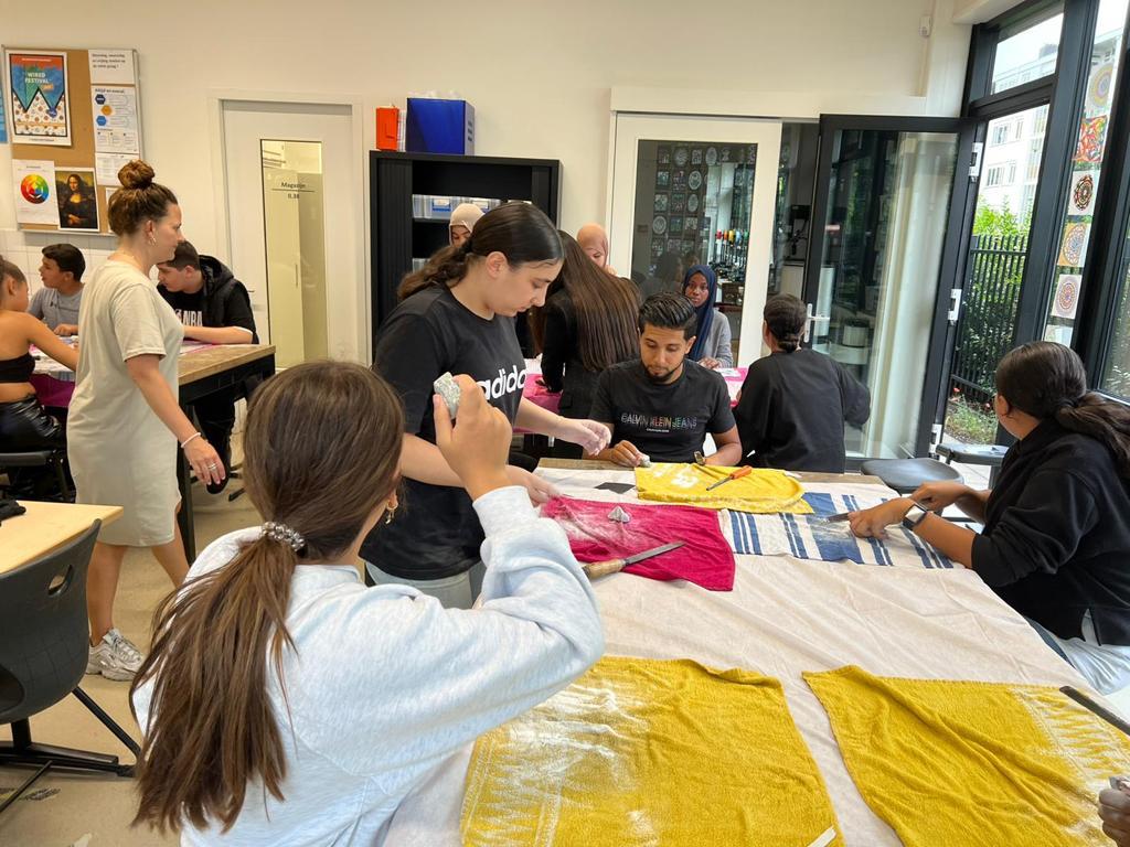 Leerlingen en begeleiders werken samen tijdens een creatieve workshop