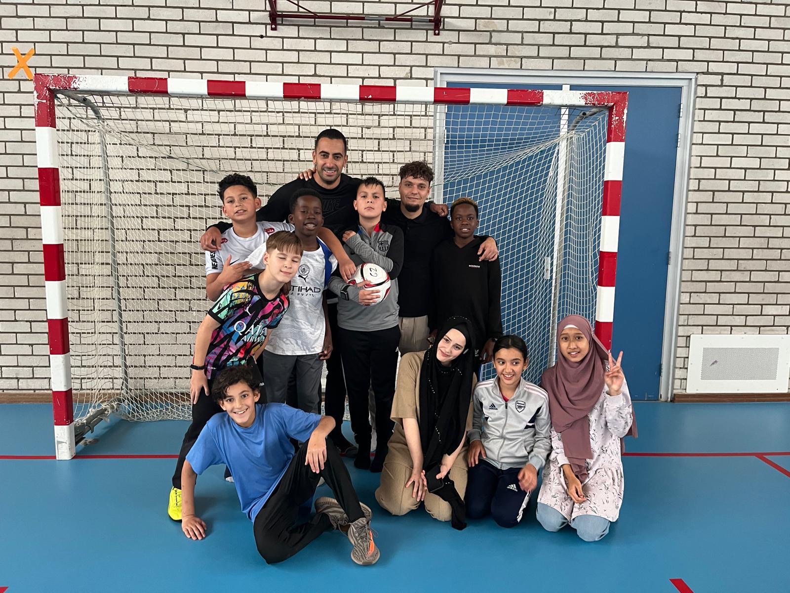 Leerlingen en begeleiders vieren samen hun teamgeest na het zaalvoetbal