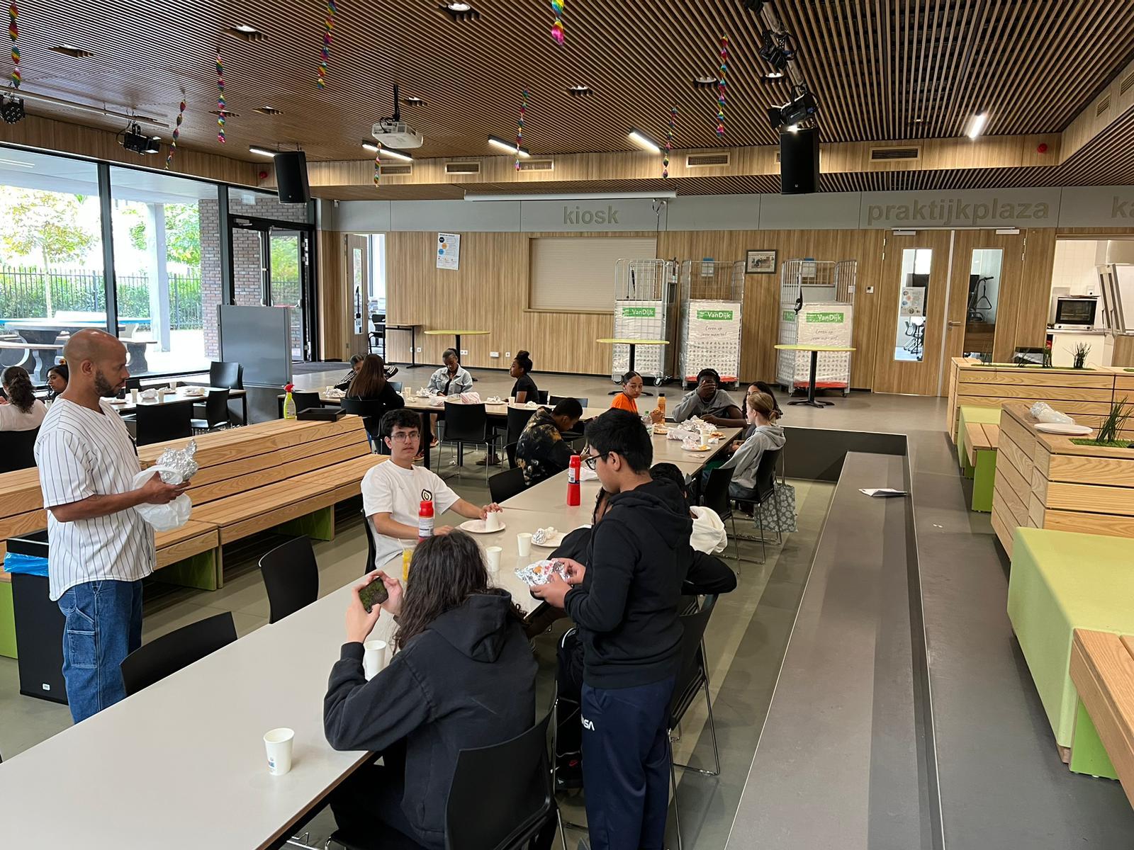 Begeleider deelt een verzorgde lunch uit in de schoolaula