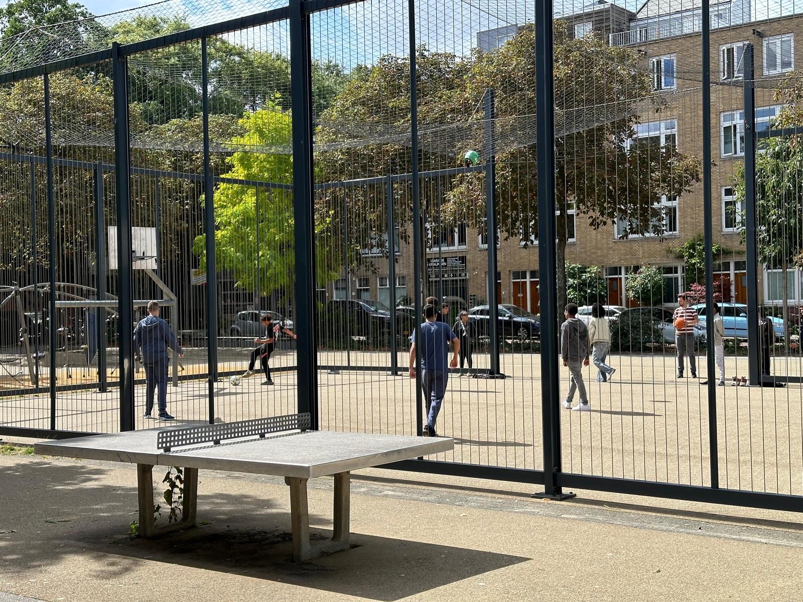 Leerlingen sporten samen op het buitensportveld bij school
