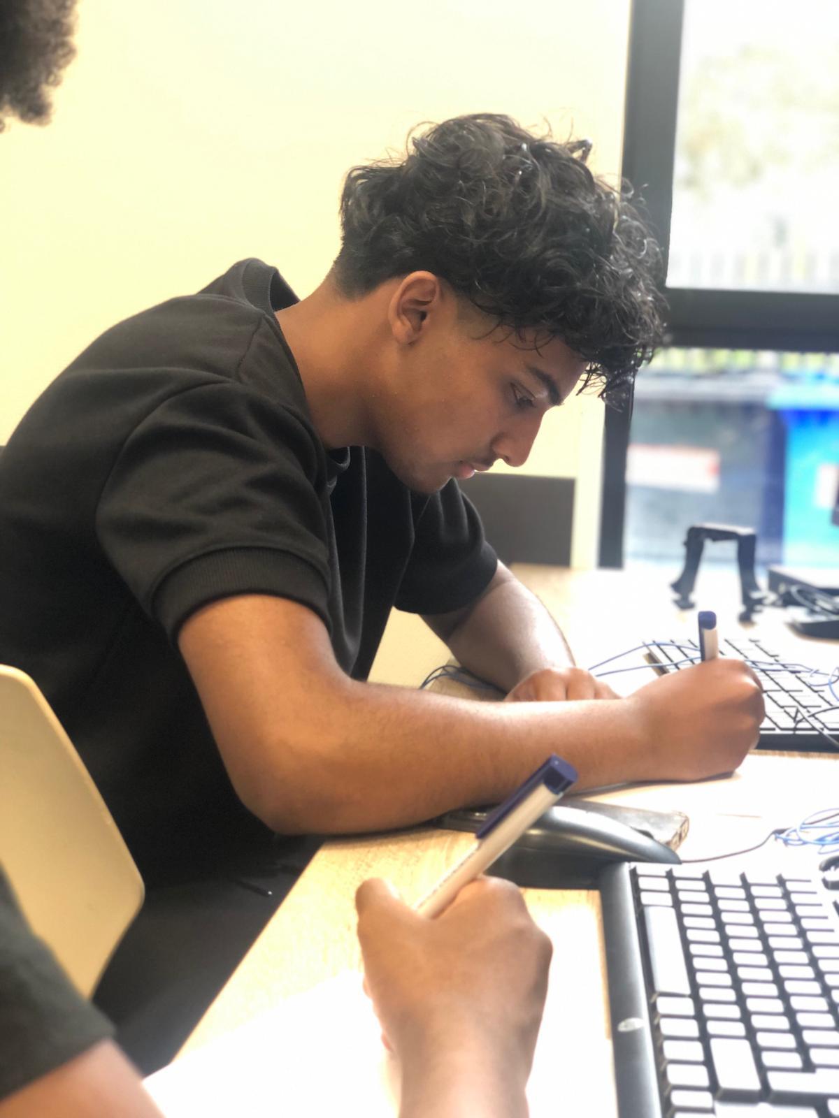 Leerling werkt diep geconcentreerd aan een examenopgave